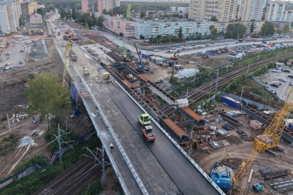 На правом направлении путепровода по шоссе Космонавтов укладывают асфальт
